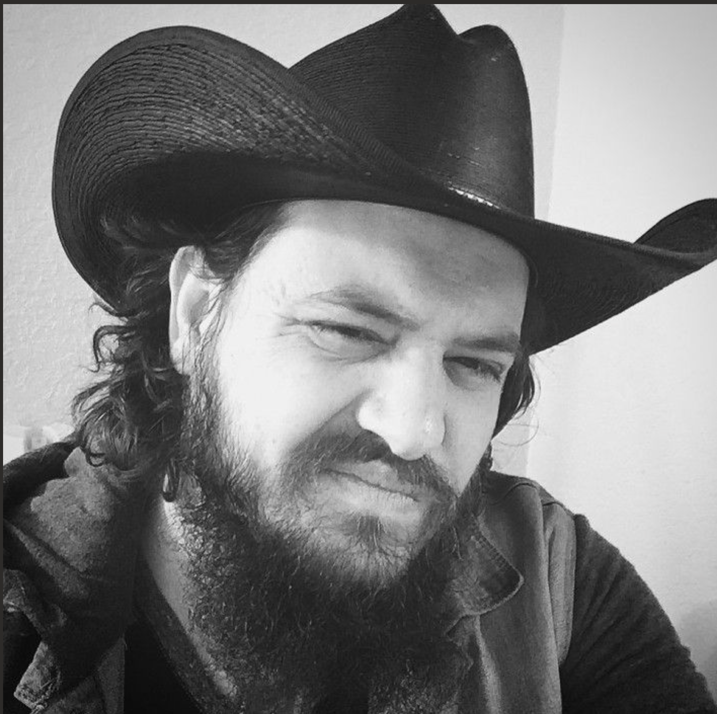The artist wearing a black cowboy hat